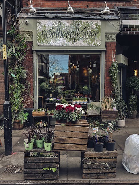 The storefront of Northern Flower, a florist specializing in floral gifts and flower delivery, is seen on a city street. The shop has a white sign with green decorative detailing and the name 'norther
